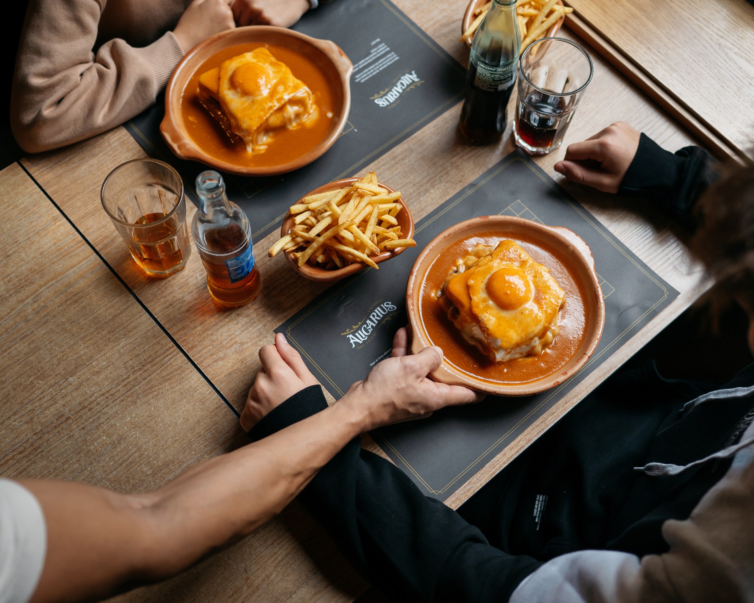 Mesa com duas francesinhas a serem servidas a clientes